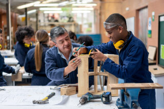 photo - Student Building Furniture with Help from Teacher